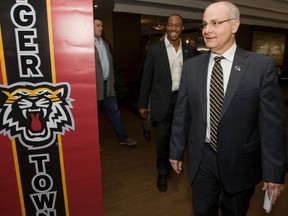 George Cortez, 60, and Henry Burris, 37, walk into Tuesday's news conference in Hamilton where they are introduced as the new coach and QB of the Tiger-Cats, respectively. (Jack Boland, Toronto Sun)
