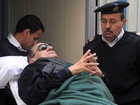 Former Egyptian president Hosni Mubarak lies on a gurney bed while leaving the courtroom at the police academy, where he is on trial, in Cairo January 2, 2012. REUTERS/Stringer