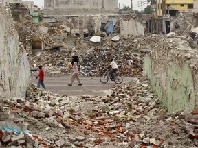 Residents walk past buildings destroyed in an earthquake in downtown Port-au-Prince September 28, 2010. REUTERS/ Eduardo Munoz
