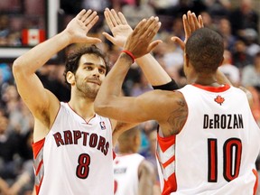 Jose Calderon high-tens teammate DeMar DeRozan during Wednesday night's win over the Cleveland Cavaliers. (REUTERS)