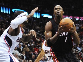 Heat forward Chris Bosh shoots around Hawks forward Josh Smith in Atlanta, Ga., Jan. 5, 2012. (TAMI CHAPPELL/Reuters)