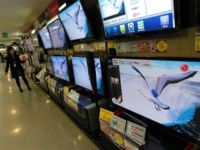A woman looks around LG Electronics television sets at an electronics shop in Seoul October 26, 2011. (REUTERS/Jo Yong-Hak)