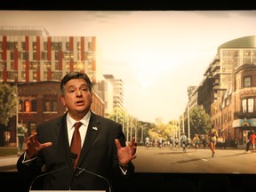 Charles Sousa, the provincial minister responsible for the 2015 Pan/Parapan Am Games in Toronto, stands in front of a mockup of what the athletes' village will look like when completed in the West Don Lands. (VERONICA HENRI/Toronto Sun)