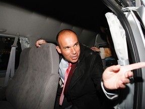 Former Olympus CEO Michael Woodford speaks to a reporter from inside a van as he leaves a news conference at the Japan National Press Club in Tokyo Jan. 6, 2012. REUTERS/Issei Kato