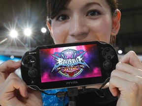 A woman shows off Sony's PlayStation Vita handheld gaming device at Tokyo Game Show in Chiba, east of Tokyo, Sept. 15, 2011.   REUTERS/Kim Kyung-Hoon