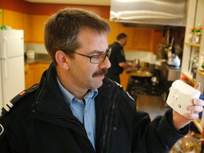 Ottawa Fire spokesman Marc Messier shows off a typical carbon monoxide detector Friday, Jan. 6, 2012, which should be installed anywhere  a fuel-burning appliance is located — like the kitchen at the fire hall. (DOUG HEMPSTEAD/Ottawa Sun/OttawaSun/QMI Agency)