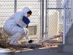 Edmonton Police Service members investigate the scene near 93 St., and 103 Ave., where a woman was found in serious condition after an  assault. TOM BRAID/EDMONTON SUN