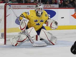 Goaltender Johan Gustafsson of Sweden makes a save on Lino Martschini of Switzerland during the 2012 IIHF U20 World Junior Hockey Championship in Calgary on Dec. 28, 2011. (Al Charest/QMI Agency)