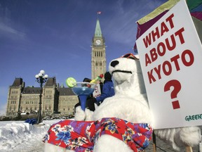 A Greenpeace activist dressed in a polar bear costume demonstrates in front of Parliament Hill to call on Canada's minority Conservative government to meet its commitments under the Kyoto Protocol, in Ottawa January 29, 2007.  (REUTERS/Chris Wattie)