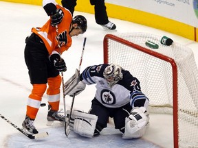 Philadelphia Flyers winger James van Riemsdyk (L) tries to redirect the puck in front of the Winnipeg Jets goalie Ondrej Pavelec (R) during the third period of their NHL ice hockey game in Philadelphia, Pennsylvania, October 27, 2011. REUTERS/Tim Shaffer (