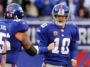 New York Giants quarterback Eli Manning (10) celebrates his third quarter touchdown pass to wide receiver Mario Manningham during their NFL NFC wildcard playoff football game in East Rutherford, New Jersey, January 8, 2012. REUTERS/Ray Stubblebine