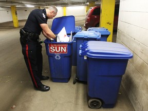 Police look for evidence inside the Edmonton Sun Building parkade after an armed robbery occurred Sunday. A suspect was arrested just outside the building. PERRY MAH/EDMONTON SUN