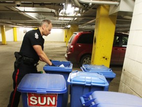 Police look for evidence inside the Edmonton Sun Building parkade after an armed robbery occurred in the area in Edmonton on Jan. 8. (PERRY MAH/QMI AGENCY)