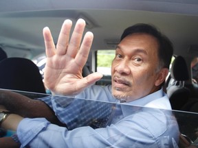 Malaysia's opposition leader Anwar Ibrahim waves to his supporters after he was acquitted of sodomy charges as he leaves the courthouse in Kuala Lumpur January 9, 2012. (REUTERS/Bazuki Muhammad)