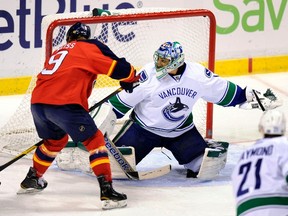 Vancouver Canucks goalie Roberto Luongo (R) stops a shot on goal by Florida Panthers' Stephen Weiss (L) during the first period of their NHL hockey game in Sunrise, Florida January 9, 2012. (REUTERS/Rhona Wise)