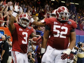 Alabama Crimson Tide running back Trent Richardson (left) celebrates with teammates Alfred McCullough after scoring a touchdown against the LSU Tigers during their NCAA BCS game in New Orleans on Monday night.. (Reuters)
