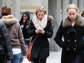 Walking and texting at the same time — as seen here Tuesday on Yonge St. —could be hazardous to your health. (DAVE ABEL/Toronto Sun)