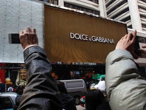 People take photos outside the flagship store of Dolce & Gabbana in Hong Kong January 8, 2012. (REUTERS/Bobby Yip)