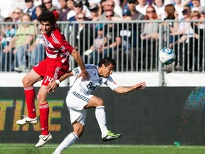 Vancouver Whitecaps' Camilo (R) chases down the ball next to FC Dallas' George John during the second half of their MLS soccer game in Vancouver, British Columbia April 23, 2011.  (REUTERS/Ben Nelms)