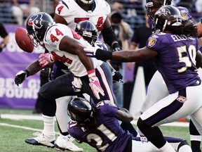 Houston Texans' running back Ben Tate (44) fumbles the football after getting hit by Baltimore Ravens' cornerback Lardarius Webb (21) as linebacker Dannell Ellerbee (59) moves in during the second quarter of their NFL football game in Baltimore, Maryland October 16, 2011. (REUTERS/Joe Giza)