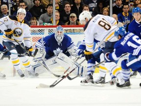 Maple Leafs goalie Jonas Gustavsson keeps his eye on the action as Buffalo Sabres center Luke Adam looks for a pass in Buffalo on Friday. (REUTERS/Doug Benz)