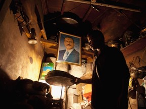 A shopkeeper works below a portrait of Yemen's outgoing president Ali Abdullah Saleh in his shop in Souq Al-Melh marketplace in the Old City in Sanaa January 16, 2012. (REUTERS/Mohamed al-Sayaghi)