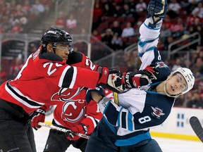 New Jersey defenceman Bryce Salvador (24) hits Winnipeg Jets centre Alex Burmistrov during the first period Tuesday at the Prudential Center in Newark, N.J. (ED MULHOLLAND/US Presswire)