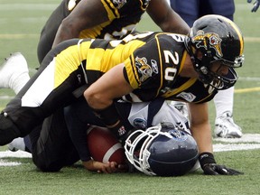 Toronto Argonauts quarterback Cleo Lemon is sacked by Hamilton Tiger-Cats safety Dylan Barker (20) during the second half of their CFL football game in Hamilton, September 6, 2010. (REUTERS/Mike Cassese)
