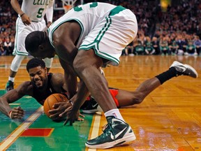 Raptors forward Amir Johnson fights for a loose ball with Celtics forward Brandon Bass during last night’s game in Boston. (REUTERS)