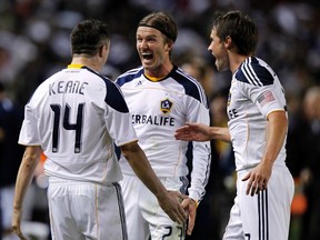 Los Angeles Galaxy forward Robbie Keane celebrates his goal against Real Salt Lake with midfielder David Beckham (23) and defender Todd Dunivant (R) during the second half of their MLS western conference playoff soccer game in Carson, California November 6, 2011.  (REUTERS/Alex Gallardo)