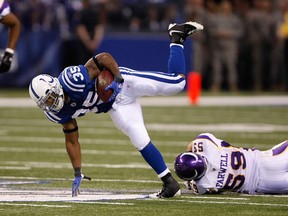 Indianapolis Colts running back Chad Simpson is tripped up by Minnesota Vikings linebacker Heath Farwell Aug. 14, 2009 in Indianapolis, Indiana. (AFP-GETTY IMAGES)