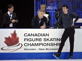 Patrick Chan (right) talks with Mike Slipchuk (centre), Skate Canada's director of high performance, and William Thompson (left), Skate Canada's CEO, during a practice session at the Canadian Figure Skating Championships in Moncton, N.B., on Thursday.  (REUTERS)
