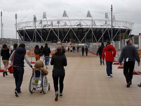 People walk past the Olympic Stadium inside the Olympic Park in London on Dec. 4, 2011. (REUTERS/Eddie Keogh)