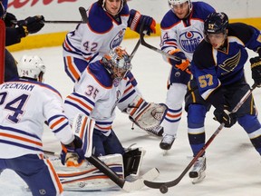Oilers goaltender Nikolai Khabibulin comes under fire during second-period action against the Blues Thursday in St. Louis. (Reuters)