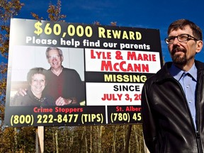 Brett McCann, son of Lyle and Marie McCann, poses next to a billboard advertising a reward for the missing couple in Alberta in this September 30, 2011 file photo. (CODIE MCLACHLAN/QMI Agency)