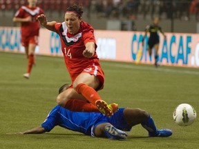 Haiti's Carmela Aristide tackles Canada's Melissa Tancredi their CONCACAF women's Olympic qualifying game in Vancouver, B.C., Jan. 19, 2012. (ANDY CLARK/Reuters)