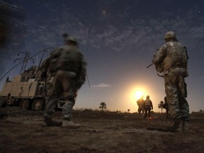 U.S. Army soldiers watch illumination rounds during a night patrol near Camp Kalsu in Tunis, Iraq Dec. 5, 2011. (REUTERS/Shannon Stapleton)