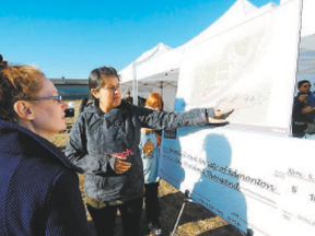 Felicia Dewar points out the design plans for a new neighbourhood park to a Brintnell resident. Trevor Robb/QMI Agency