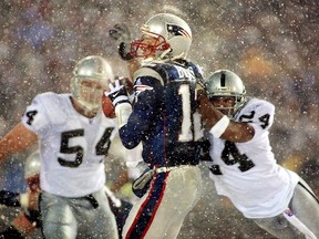 New England QB Tom Brady gets hit in the 2002 playoff game against the Oakland Raiders that was ultimately decided by the Tuck Rule. (GETTY IMAGES)