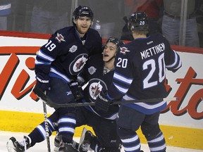 Burmistrov (centre), who saw time on the top line, celebrates his third-period goal with Jim Slater (left) and Antti Miettinen. (JASON HALSTEAD/Winnipeg Sun)