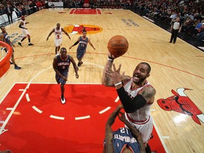 Carlos Boozer of the Chicago Bulls shoots a layup against Tyrus Thomas #12 of the Charlotte Bobcats during the NBA game on January 21, 2012 at the United Center in Chicago, Illinois. (Gary Dineen/NBAE via Getty Images/AFP)