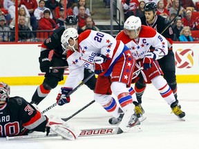 Capitals forward Troy Brouwer goes for a loose puck in front of Hurricanes goaltender Cam Ward at the RBC Center in Raleigh, N.C., Jan. 20, 2012. (JAMES GUILLORY/US Presswire)