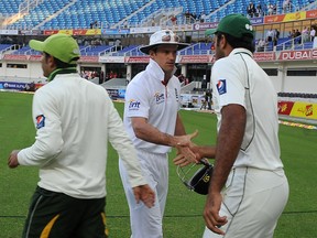 England's cricket captain Andrew Strauss (centre) shakes hands with Pakistan's cricketer Wahab Riaz (right) following the latter's team victory in the opening Test match between Pakistan and England at the international cricket stadium at Dubai Sports City on Thursday.  Paceman Umar Gul took 4-63 to help Pakistan beat the world's best Test team by 10 wickets in the first Test inside three days in the Gulf emirate, gaining a 1-0 lead in the three-match series. (AFP PHOTO/LAKRUWAN WANNIARACHCHI)