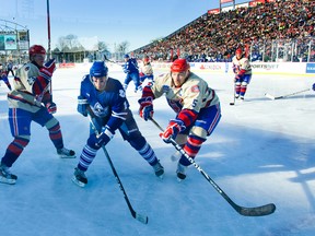Toronto Marlies' Will Acton and Hamilton Bulldogs' Alex Henry battle for the puck during Saturday's AHL Outdoor Classic at Ivor Wynne Stadium in Hamilton. (ERNEST DOROSZUK/Toronto Sun)