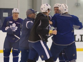 Joey Crabb (second from right) and Carl Gunnarsson (36) are pulled apart after a brief scuffle at Maple Leafs' practice on Sunday. (Jack Boland/QMI Agency)