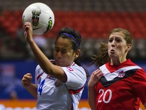 Costa Rica's Marianne Ugalde and Canada's Chelsea Buckland go after the ball during their CONCACAF women's Olympic qualifying soccer match at BC Place in Vancouver, B.C., Jan. 23, 2012. (ANDY CLARK/Reuters)