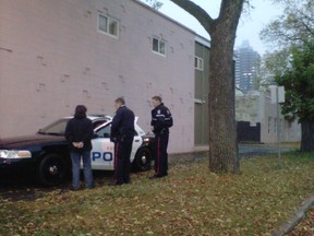 Two Edmonton Police Service officers ticket a young woman for consuming alcohol in public during the Edmonton Police Service's walk through of troubled neighborhoods in the Central McDougall neighborhood in Edmonton, AB on October 5, 2011.  JACKIE LARSON/EDMONTON SUN QMI AGENCY