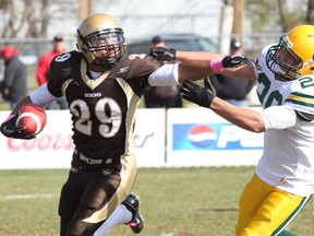 University of Alberta linebacker Connor Ralph, right, seen here chasing a University of Manitoba running back last season, has been selected to Team World for a game against Team USA on Feb. 1 in Austin, Texas. (QMI Agency)