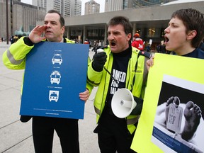 Robert Boyd, Mike Merriman, and Leanne Duke Holmes rally outside City Hall. Paramedics, EMS Professionals and supporters from Toronto and across the province held a rally in Nathan Phillips Square and made deputations before Toronto Council's executive committee Tuesday. (CRAIG ROBERTSON/Toronto Sun)