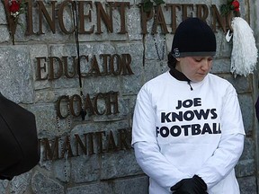 A student mourns before former Penn State head football coach Joe Paterno's hearse travels past Beaver Stadium en route to his burial site in State College, Penn., on Wednesday, Jan. 25, 2012. (REUTERS/Craig Houtz)